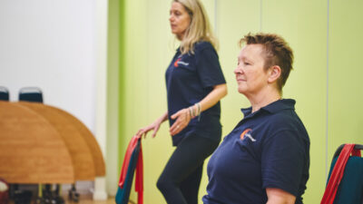 iCareiMove instructors lead an Impact class with sitting and standing gentle exercises.