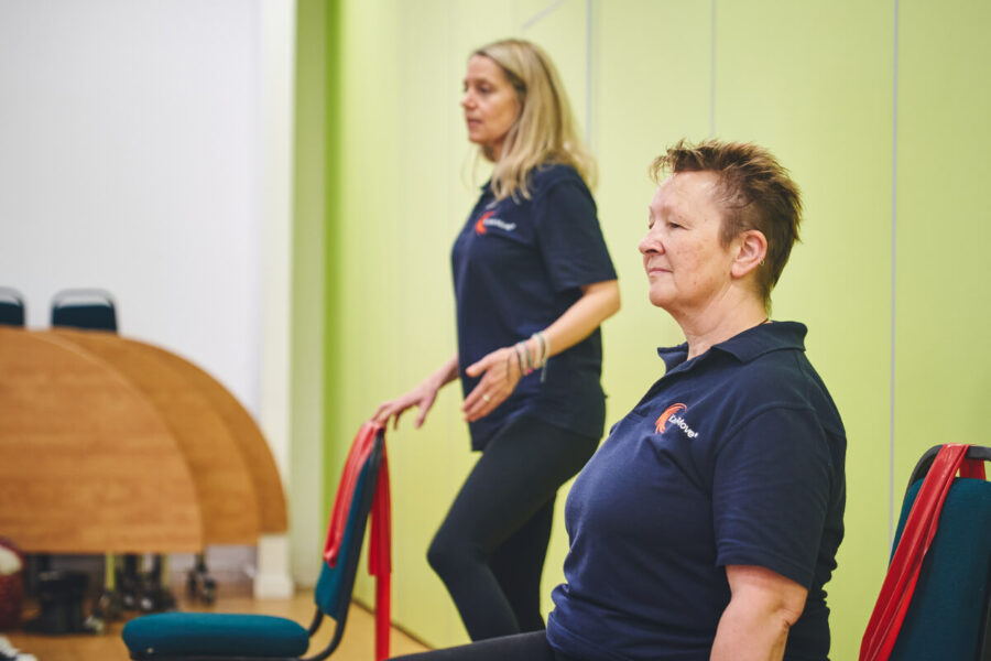 iCareiMove instructors lead an Impact class with sitting and standing gentle exercises.