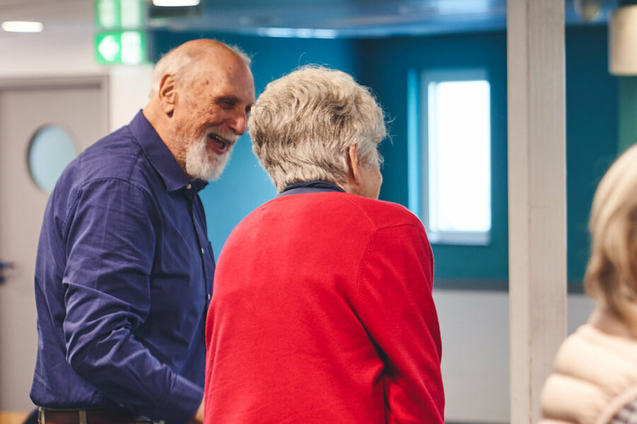 An older couple laughing while at a falls prevention group exercise class.