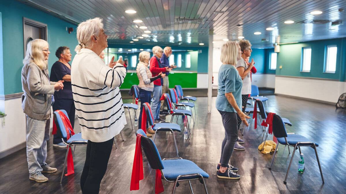 A group of older participants doing group falls prevention exercise activities at an iCareiMove Impact Event.