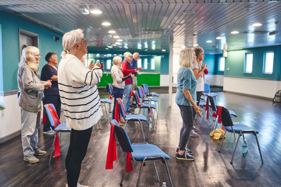 A group of older participants doing group falls prevention exercise activities at an iCareiMove Impact Event.